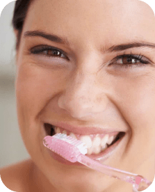 Une jeune femme se brosse les dents.